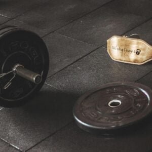 Barbell, plates and a belt on a floor