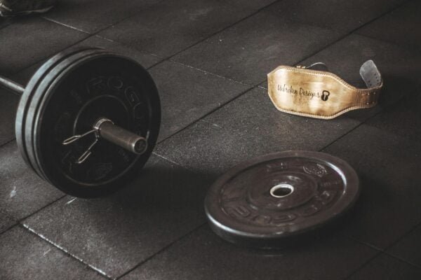 Barbell, plates and a belt on a floor