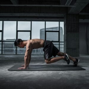 Man doing mountain climbers indoors in a fitness studio