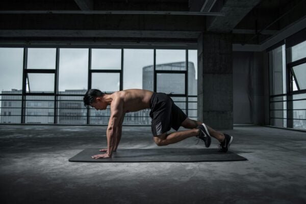 Man doing mountain climbers indoors in a fitness studio