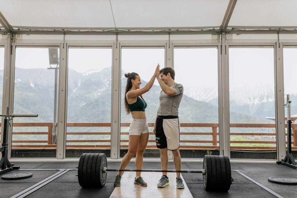 Two people high fiving in the gym